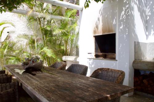drewniany stół na patio z krzesłami w obiekcie Santa Cruz Ocean Villa w mieście Gaula