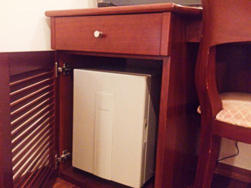 a wooden cabinet with a computer system in it at Hotel Sun Queen in Naha