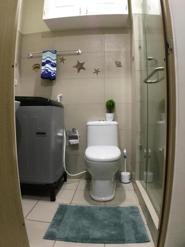 a bathroom with a toilet and a glass shower at 1237 Winds Residences in Tagaytay