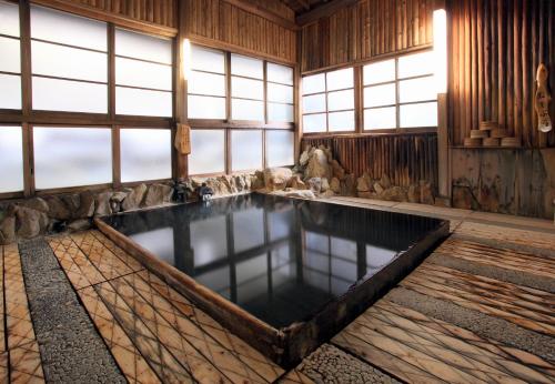una piscina cubierta en una habitación con ventanas en Ryokan Adumaya en Hongu
