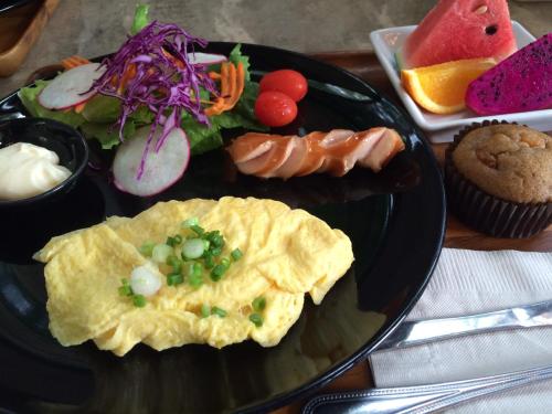 a plate of food with an omelet and other foods at The Wishes Hotel at Chiangmai in Chiang Mai