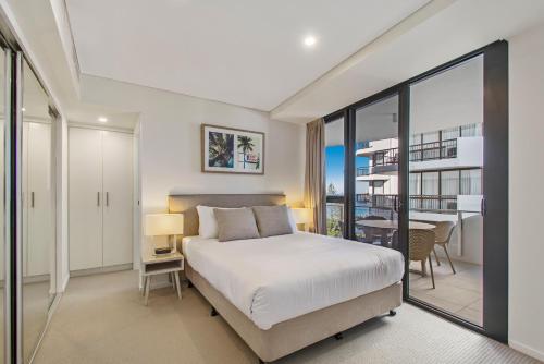 a bedroom with a bed and a balcony with a table at Breeze Mooloolaba, Ascend Hotel Collection in Mooloolaba