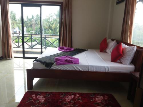 a bedroom with a bed with purple towels on it at Blue Diamond Hostel in Battambang