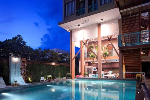 a swimming pool in front of a building at night at Lub d Cambodia Siem Reap in Siem Reap