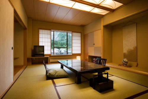 a dining room with a table and a window at Kansyokan in Mogami