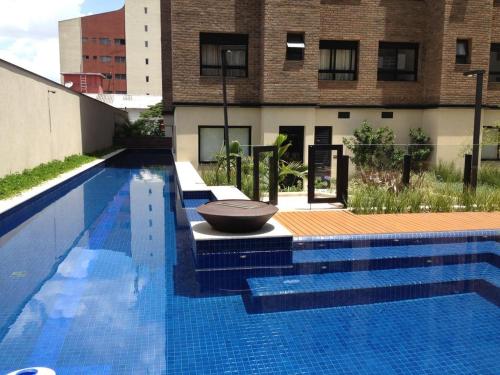 una gran piscina azul con un tazón encima en Apartamentos Vila Madalena, en São Paulo