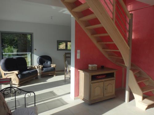 una sala de estar con una pared roja y una escalera en Cora Venez en Saint-Bresson