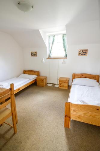 a bedroom with two beds and a window at Penzion Vědomice in Vědomice