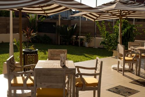 a patio with tables and chairs under an umbrella at Golden Tulip Stone Town Boutique in Zanzibar City