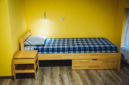 a bedroom with a bed with a yellow wall at Alina Hotel & Hostel in Uzhhorod
