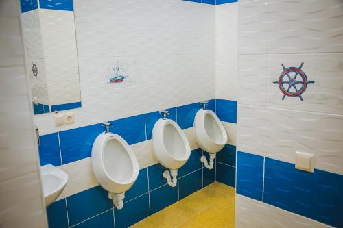 a bathroom with three urinals on a wall at Alina Hotel & Hostel in Uzhhorod