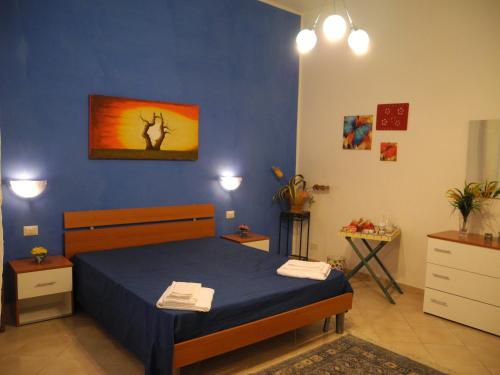 1 dormitorio con cama y pared azul en CASA Melone Giallo, en Paceco