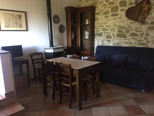 a living room with a table and a couch at Casale degli ulivi in Gualdo Tadino