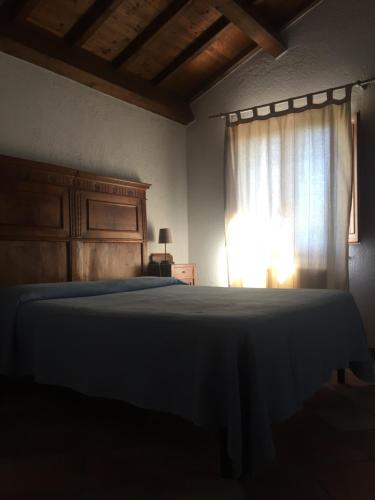 a bedroom with a bed and a window at Casale degli ulivi in Gualdo Tadino