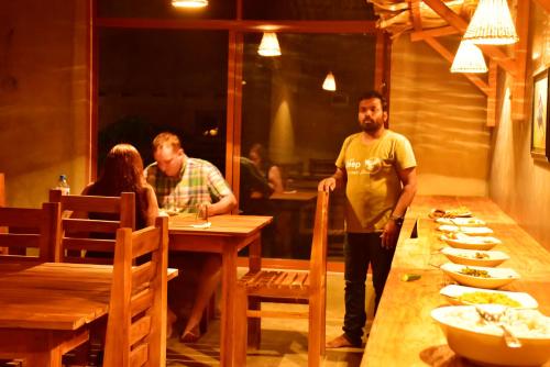 a group of people standing around a table in a restaurant at Lizard Safari Lodge in Udawalawe