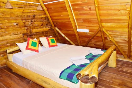 a bedroom with a bed in a log cabin at Lizard Safari Lodge in Udawalawe
