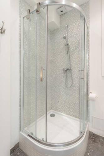 une douche avec une porte vitrée dans une salle de bain dans l'établissement La Terrasse Du Sorbonne, à Paris