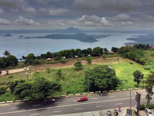 a road with a red car driving down the road at Lake View Condo at Wind Residences Tagaytay in Tagaytay
