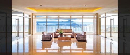 a living room with a couch and chairs and a table at Lake View Condo at Wind Residences Tagaytay in Tagaytay
