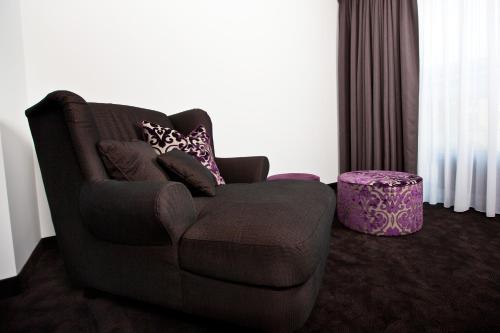 a living room with a brown couch and a stool at Goodman's Living in Berlin