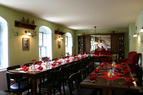 een lange tafel in een kamer met rode bloemen erop bij Alte Apotheke in Radebeul
