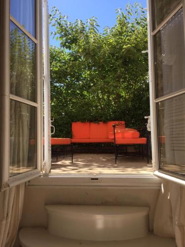 an open window with a red bench in the yard at Hôtel Particulier Le 28 - Spa & Art Luxury Design by Alain Ducasse in Aix-en-Provence