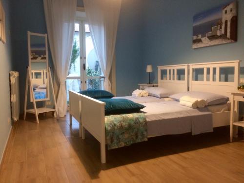 Un dormitorio con una gran cama blanca y una ventana en Gli dei e le Rose, en Agerola