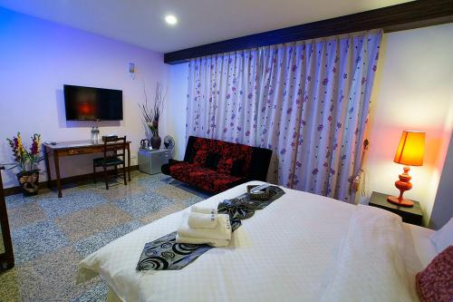 a bedroom with a bed and a couch and a television at 台東市安慶67套房館歡迎短租長租 in Taitung City
