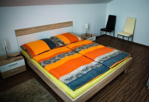 a bedroom with a large bed and two chairs at Tobzos-patak Vendégház in Viszák