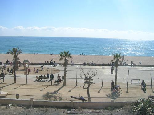 a group of people on a beach with the ocean at Apartment Beach Front Canet in Canet de Mar
