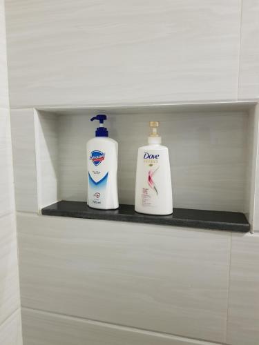 two bottles ofodorizers sit on a shelf in a bathroom at The Leaf House in Manila