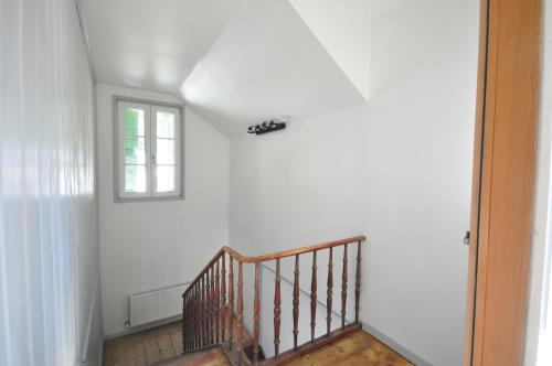 a hallway with a staircase with a window at Jungfrau Family Holiday Home in Matten