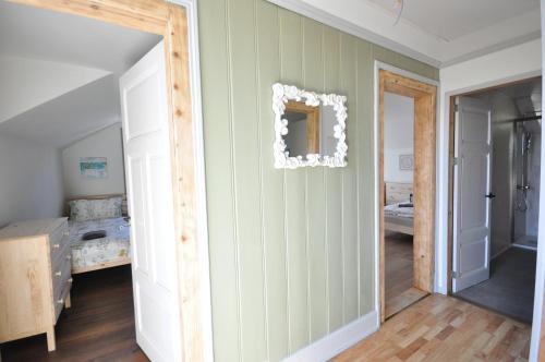 una camera da letto con pareti a righe verdi e uno specchio di Jungfrau Family Holiday Home a Matten