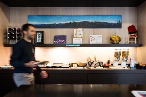 ein Mann, der hinter einer Theke in einer Küche steht in der Unterkunft La Trobada Hotel Sport in Ripoll