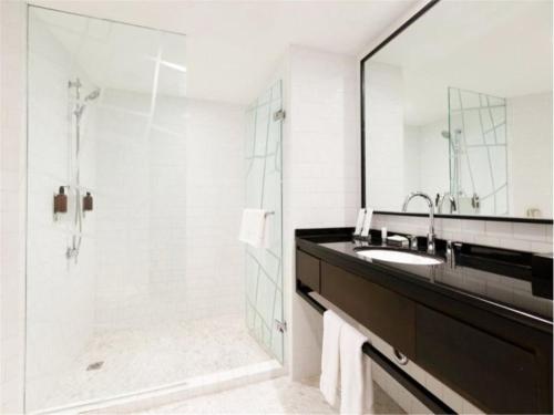 y baño con ducha, lavabo y espejo. en pentahotel Beijing, en Beijing