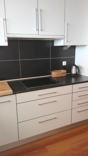 a kitchen with white cabinets and a black counter top at Casa dos Arcos in Caramulo
