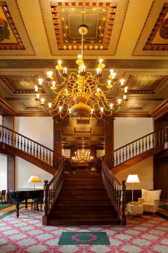a large lobby with a staircase and a chandelier at Vienna House by Wyndham Thüringer Hof Eisenach in Eisenach