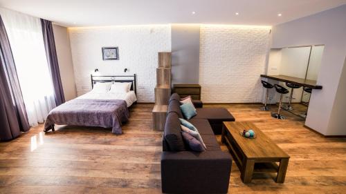 リヴィウにあるFoxy Lvivのベッドルーム1室(ベッド1台、ソファ、テーブル付)