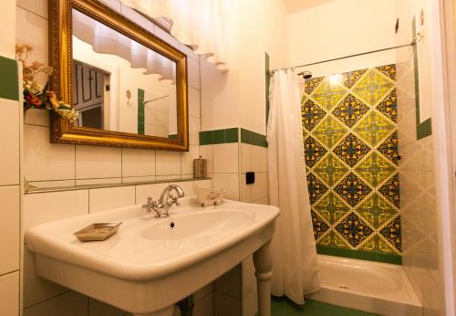 a bathroom with a sink and a mirror and a shower at Dimora Antica Pianella in Pianella