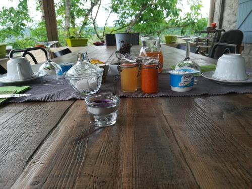 ein Holztisch mit Gläsern und Flaschen darauf in der Unterkunft Le Mas des Papillons in Fargues
