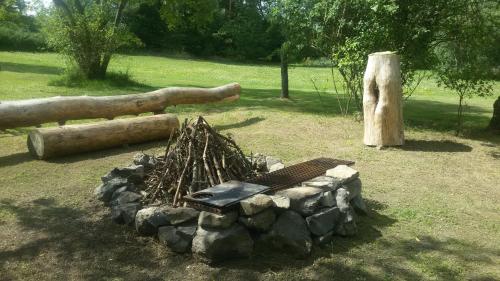 a pile of logs and a fire pit in a park at Forest Romantic Apartment Brdy in Věšín