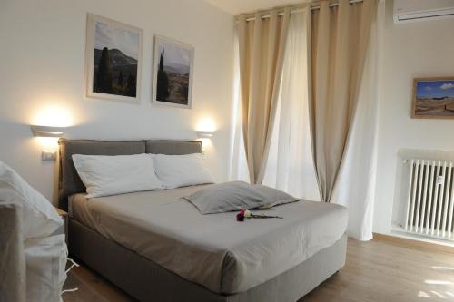 a bedroom with a bed with white walls and curtains at Piccolo Borgo Antico in Florence