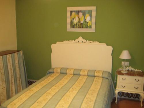 a bedroom with a bed and a lamp at Pensión Bienvenido in Seville