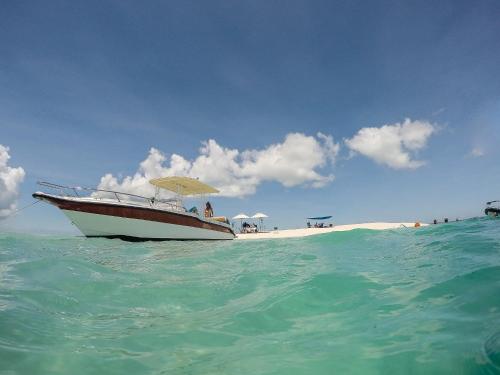 a boat with an umbrella sitting in the ocean at Beach House in Vilanculos