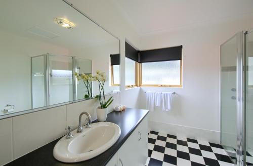 a bathroom with a sink and a mirror at Pelicans Albany Middleton Beach in Albany