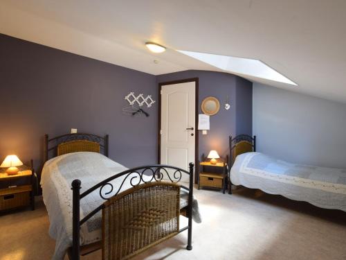 two beds in a bedroom with blue walls at Holiday Home in Ardennes with Sauna in Jehonville