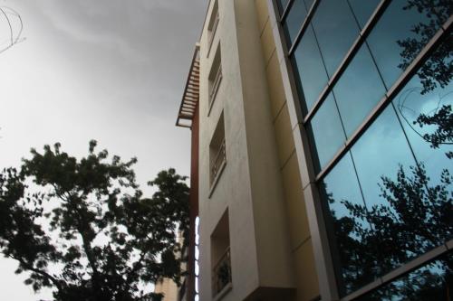 a building with glass windows and trees in the foreground at Pebbles in Chennai