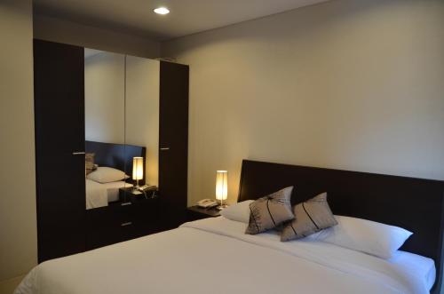 a bedroom with a large white bed with a mirror at Bangkok Living in Bangkok