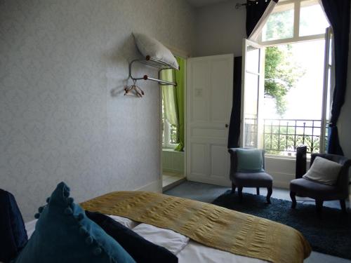 a bedroom with a bed and a window and a chair at Le Belvedere des Remparts in Langres