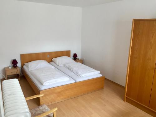 Schlafzimmer mit einem Bett mit weißer Bettwäsche in der Unterkunft Hotel Stadt Mainz in Schwabenheim